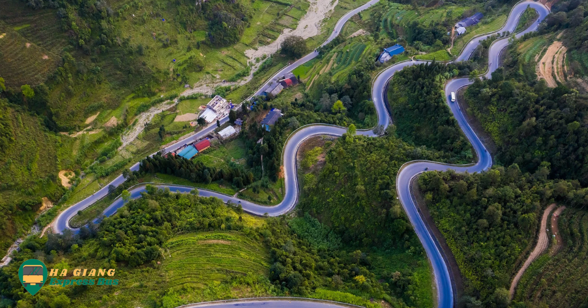 A winding mountain road carved into the rocky cliffs of Ma Pi Leng Pass, with steep drop-offs and breathtaking views of the valley below